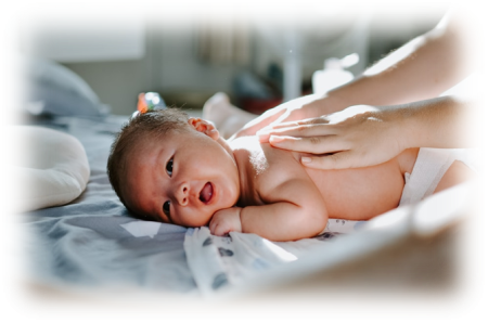 Image shows a baby lay on their tummy, receiving baby massage.